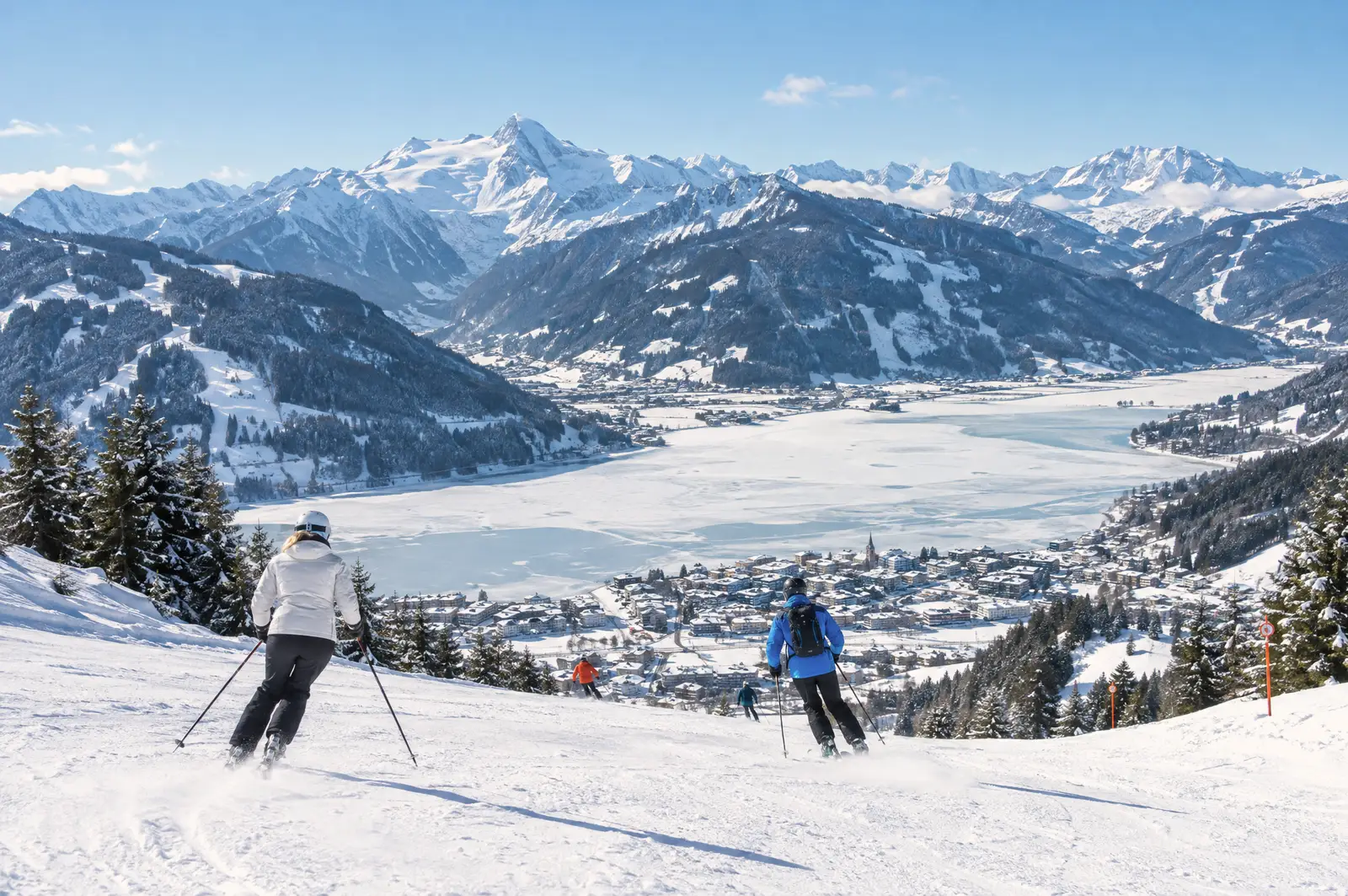 Zasněžené Zell am See u zamrzlého jezera, v pozadí hory